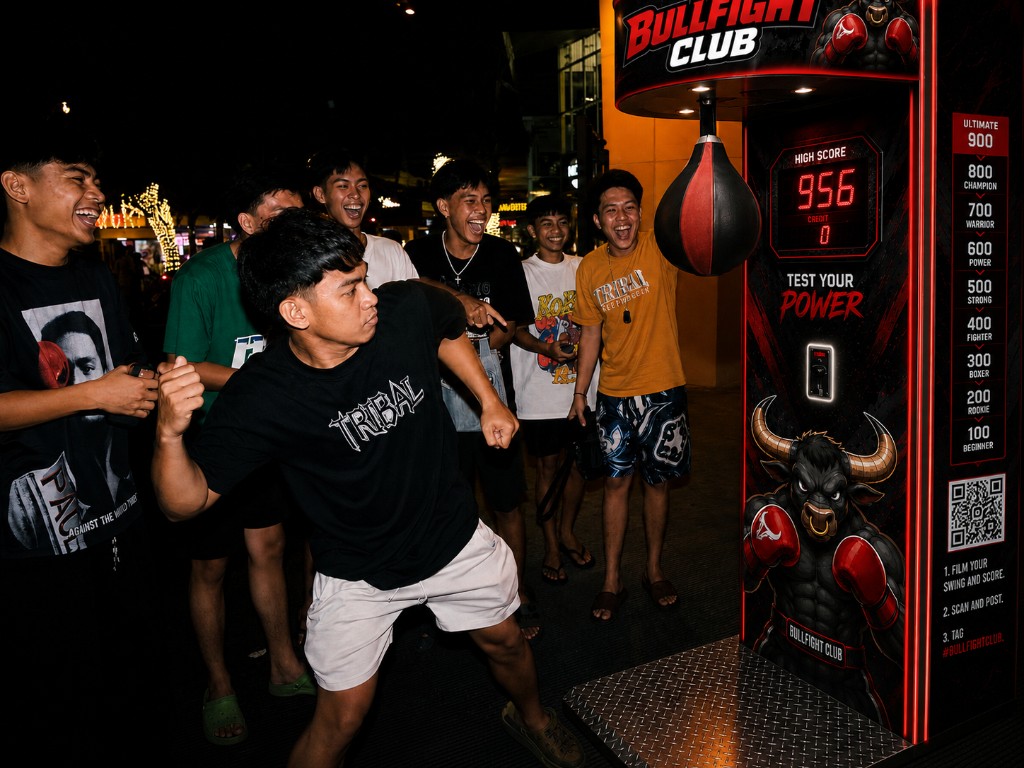 Friends cheering as a player throws a punch at a Bullfight Club machine